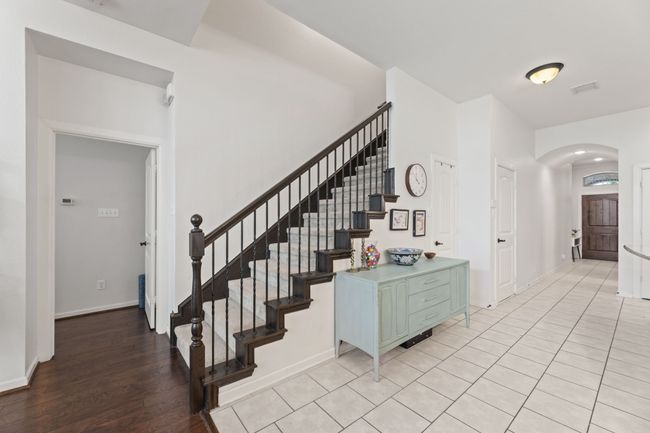 Staircase featuring arched walkways, baseboards, and wood finished floors | Image 23