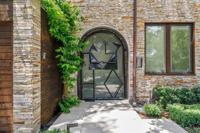 You will love the artful design of this metal and glass pivot door with swing dancer sculpture inset designed by Larry Morris of Alexandria Virginia that leads to the backyard oasis. | Image 2