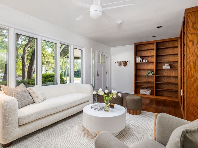 Living room with a ceiling fan, wood flooring, and built in shelves | Image 5