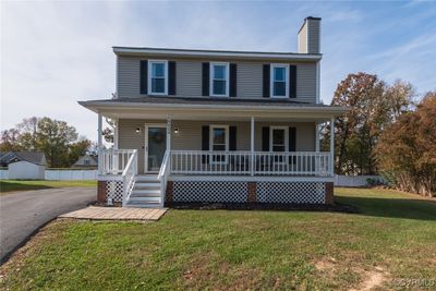 View of front facade featuring a front yard and a porch | Image 1