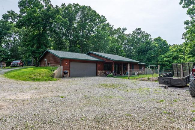 View of front of property with a garage and gravel driveway | Image 22