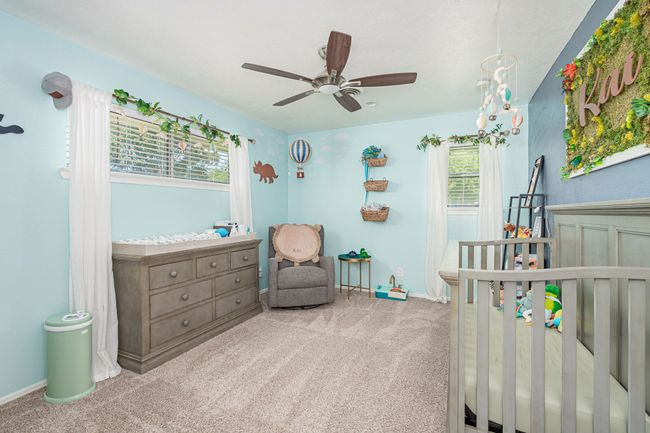 Bedroom with carpet flooring, baseboards, and a nursery area | Image 33