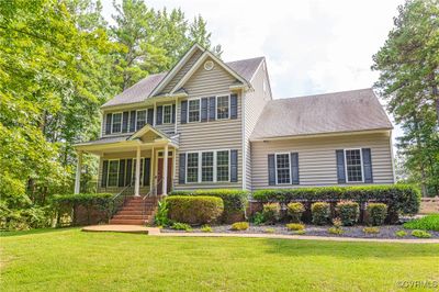 View of front facade featuring a front yard and covered porch | Image 1