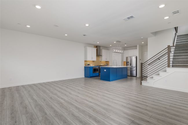 Unfurnished living room featuring light wood finished floors, stairway, and recessed lighting | Image 13