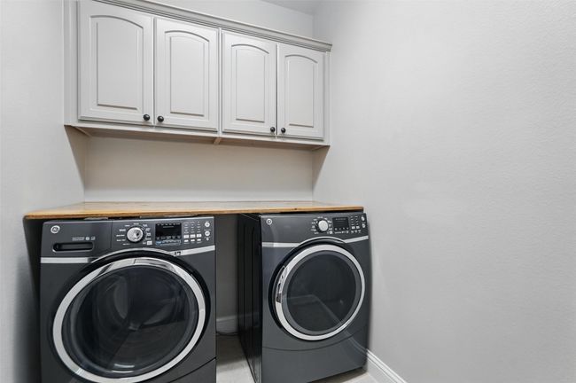 Utility room with washer and dryer, folding table on top and extra storage | Image 23