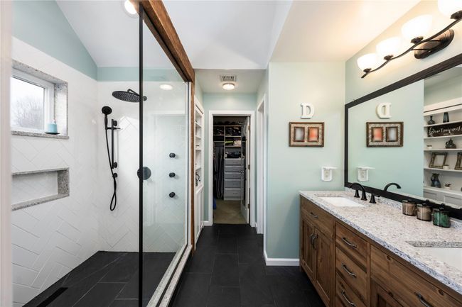 Carpeted bedroom with ceiling fan, lofted ceiling, a barn door, and a baseboard heating unit | Image 18