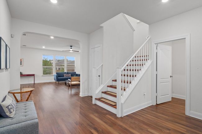 Stairs with wood finished floors, arched walkways, recessed lighting, and ceiling fan | Image 5