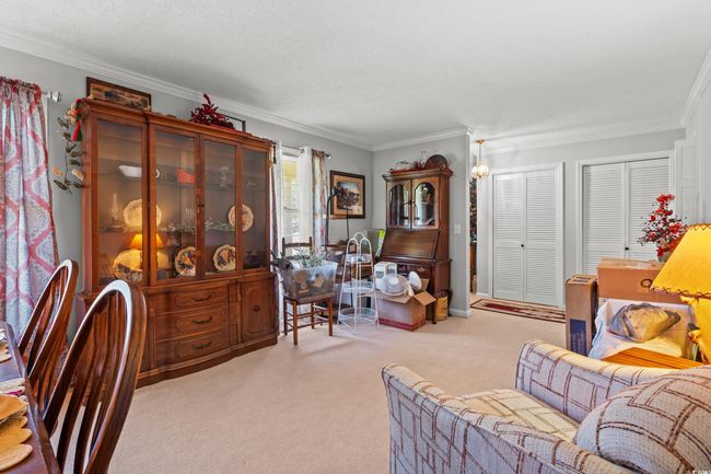 Carpeted living area with ornamental molding and a textured ceiling | Image 11