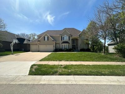 View of front facade with a front yard and a garage | Image 1