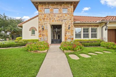 The stone surrounded front porch with coach lantern lighting has a double wrought iron gated entry that opens to a 48' covered front porch, guest casita and wine grotto area. | Image 2