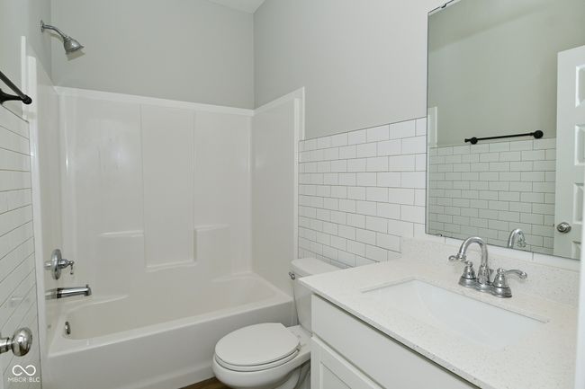 full bath with toilet, vanity, shower combination, and tile walls | Image 21