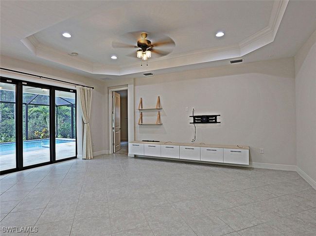 Unfurnished room featuring a raised ceiling, ornamental molding, baseboards, a ceiling fan, and recessed lighting | Image 7
