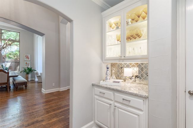 Bar area featuring arched walkways, tasteful backsplash, dark wood finished floors, and crown molding | Image 14