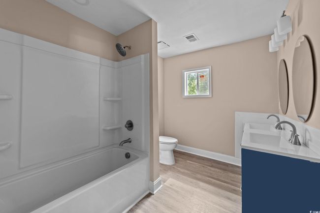 Full bath featuring shower / bath combination, wood finished floors, and double vanity | Image 28