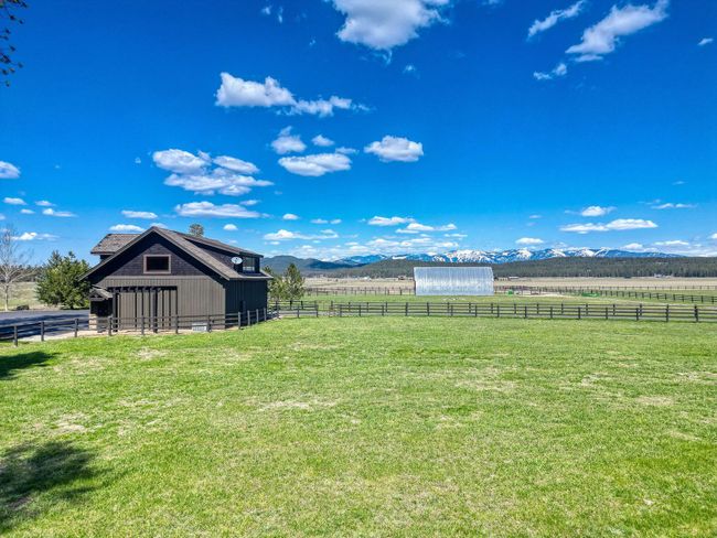 View of yard featuring a rural view, an outdoor structure, a mountain view, and an exterior structure | Image 125