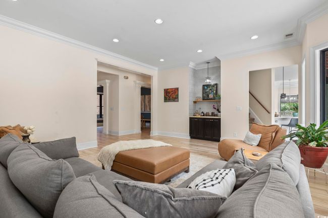 Living area featuring stairway, recessed lighting, crown molding, bar, and light wood-type flooring | Image 6