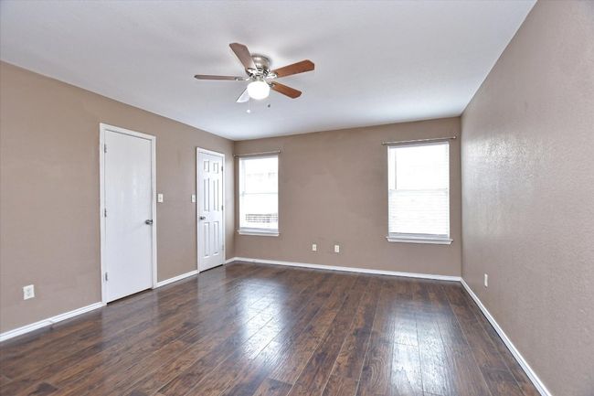 Unfurnished room featuring ceiling fan, baseboards, and dark wood-style floors | Image 15