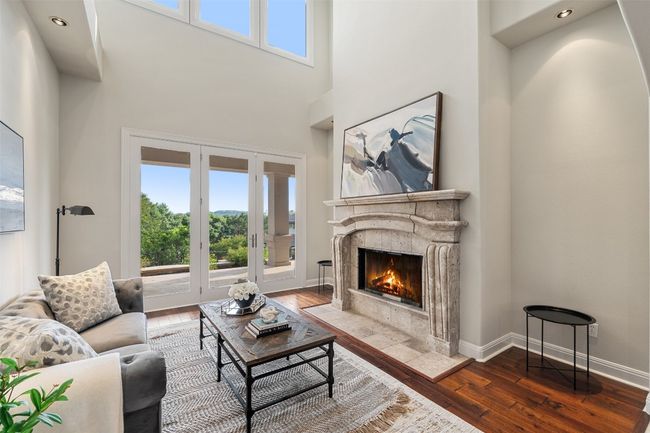 Living room with wood-type flooring, a high end fireplace, french doors, healthy amount of natural light, and a high ceiling | Image 9
