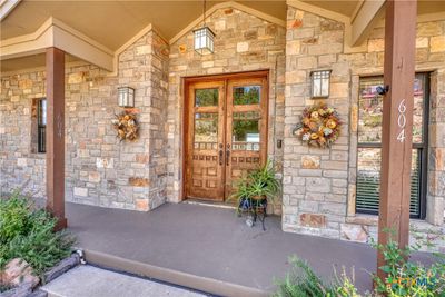 Welcome guests in style on the covered front porch, offering a cozy spot to relax and enjoy the serene surroundings. | Image 3