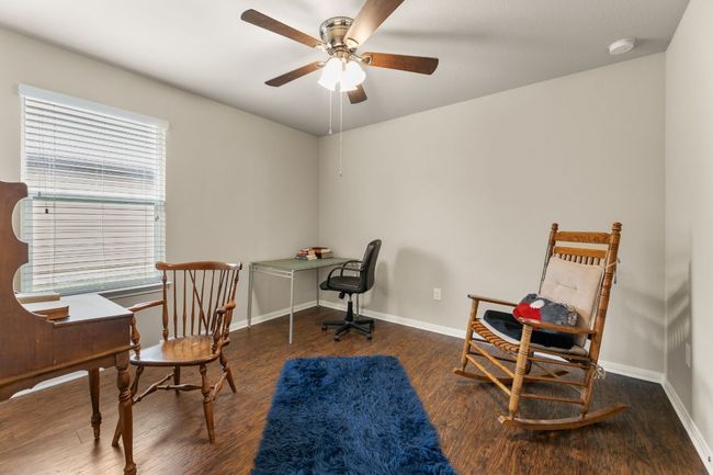 Office featuring wood finished floors, a ceiling fan, and baseboards | Image 11