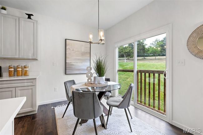 Dining room featuring dark wood finished floors, a chandelier, and baseboards | Image 15
