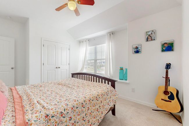 Bedroom with a closet, baseboards, a ceiling fan, carpet flooring, and lofted ceiling | Image 33