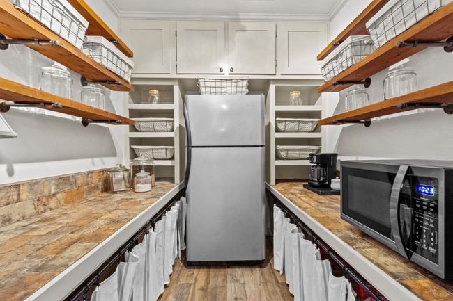 The custom walk-in pantry provides lots of extra storage, helping you keep things organized and out of sight. | Image 14