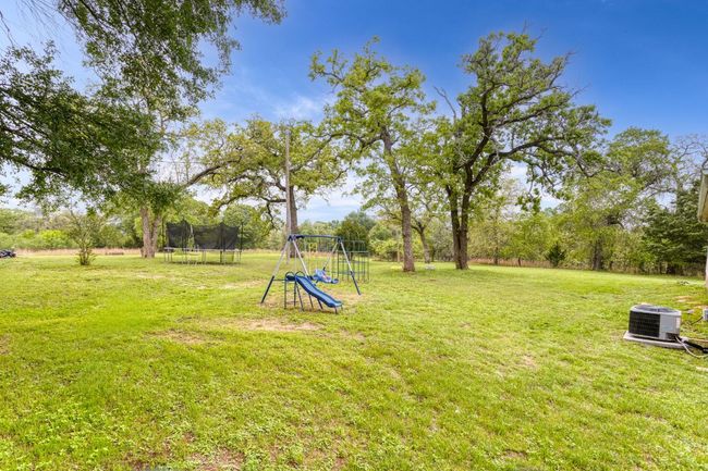 View of yard featuring central air condition unit of home. Current items in yard do not convey but show all the possibilities of 5 acres ! | Image 12