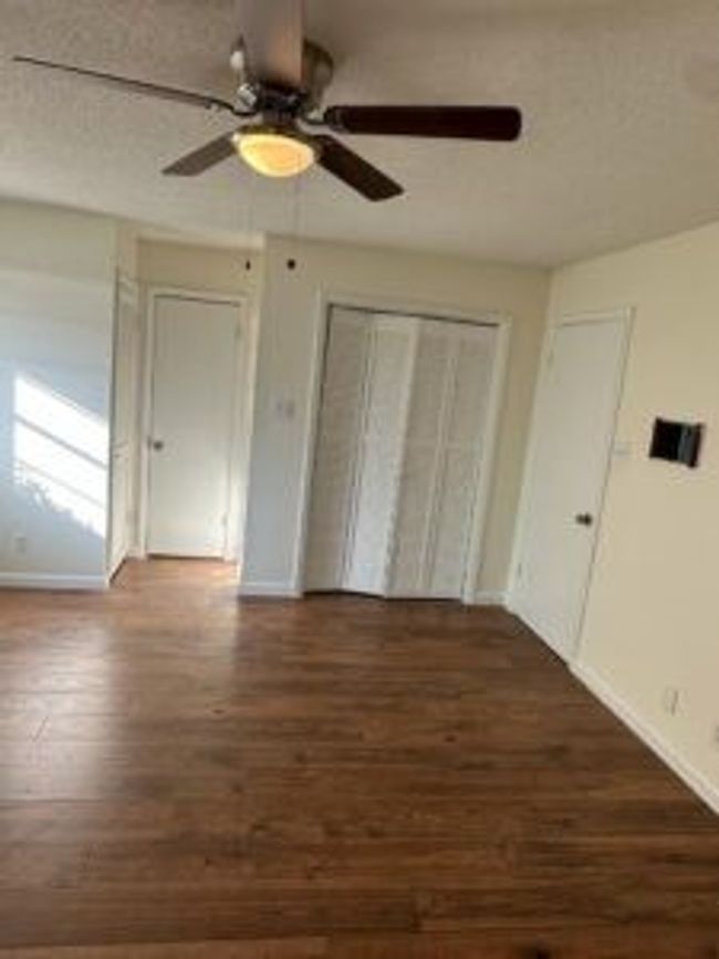 Unfurnished bedroom featuring wood finished floors, a ceiling fan, and a closet | Image 17