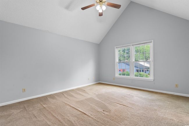 Unfurnished room with a ceiling fan, carpet, and high vaulted ceiling | Image 22