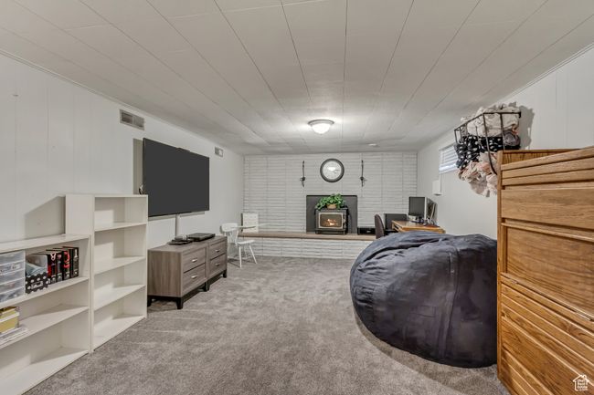 Carpeted living area with visible vents and a wood stove | Image 16