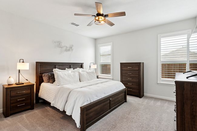 Bedroom featuring light colored carpet and ceiling fan | Image 13