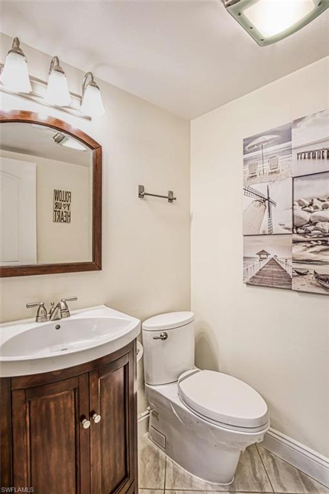 Half bath with toilet, vanity, marble finish floor, and baseboards | Image 26