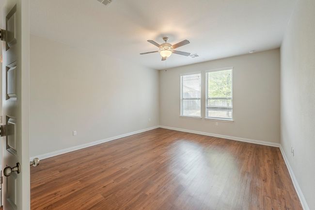 Unfurnished room with a ceiling fan, baseboards, visible vents, and dark wood-type flooring | Image 14