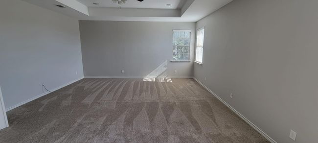 Carpeted spare room with a raised ceiling and a ceiling fan | Image 17
