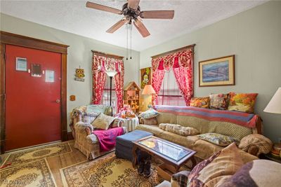 Living room with ceiling fan and a textured ceiling | Image 2