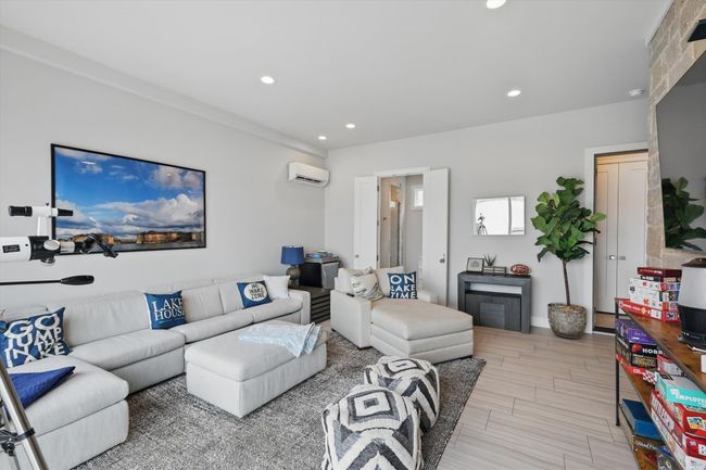 Living room featuring recessed lighting, a wall mounted air conditioner, and wood finish floors | Image 26