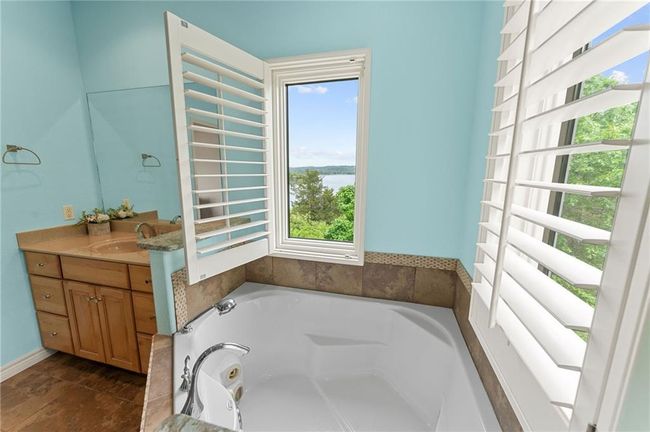 Bathroom featuring a tub with jets, vanity, and a water view | Image 29