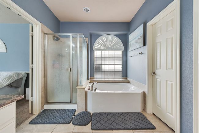Full bathroom featuring tile patterned flooring, a shower stall, a bath, and vanity | Image 15