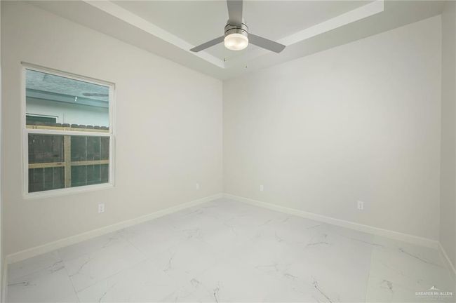 Spare room featuring light marble finish flooring, baseboards, and ceiling fan | Image 15