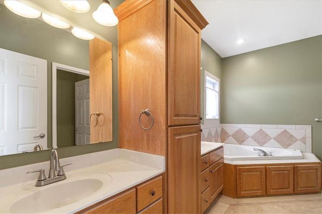 Bathroom with vanity, tile patterned floors, and a garden tub | Image 28