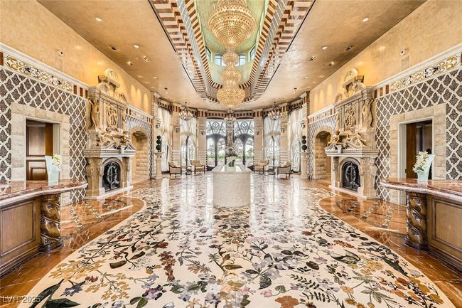 Unfurnished living room featuring a fireplace, a chandelier, a high ceiling, recessed lighting, and marble tiled flooring | Image 5