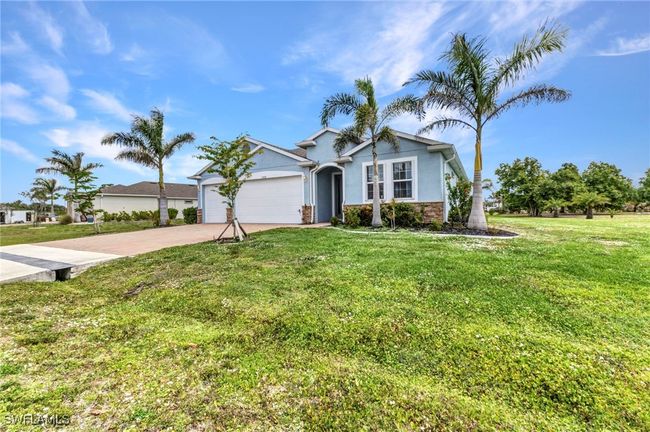 View of front of home featuring concrete driveway, stucco siding, a garage, and a front lawn | Image 46