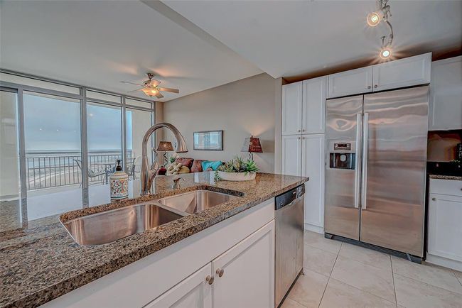 This kitchen boasts stunning granite countertops, abundant natural light, and breathtaking bay views. | Image 5