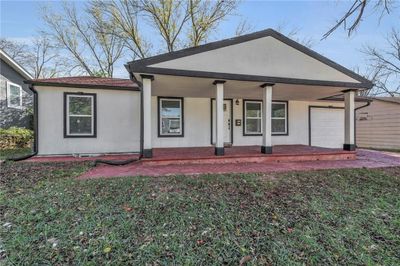 Ranch-style home featuring a garage and covered porch | Image 1