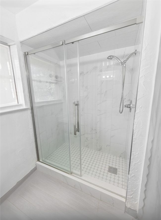 Bathroom featuring a shower with shower door | Image 9