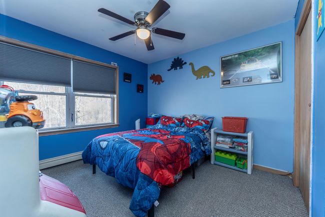 Carpeted bedroom featuring a baseboard radiator, ceiling fan, and baseboards | Image 39