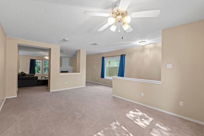 Unfurnished living room featuring a ceiling fan, a textured ceiling, carpet, and baseboards | Image 5