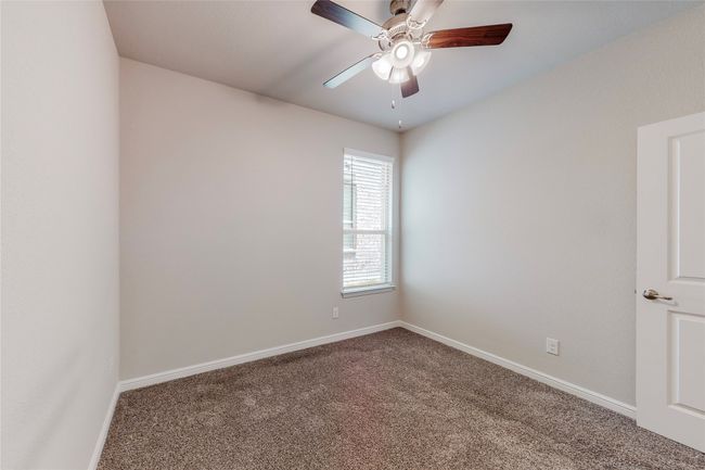 Carpeted empty room with a ceiling fan and baseboards | Image 23