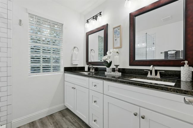 Upstairs second primary full bath featuring double vanity and wood-like finished floors | Image 21